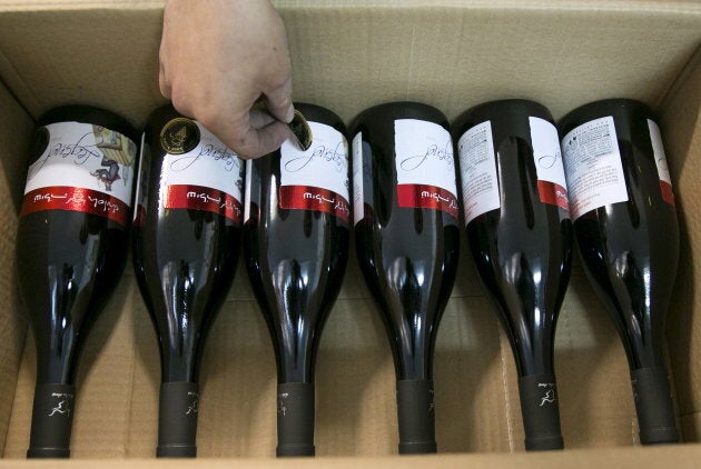 A worker places stickers on wine bottles while packaging them for export at Shiloh Wineries, north of the West Bank city of Ramallah Nov. 8, 2015.