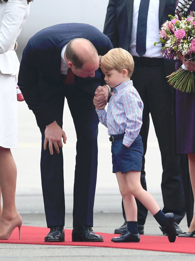 Prince William bending down to speak to his son at Warsaw airport. (Photo by Karwai Tang/WireImage)