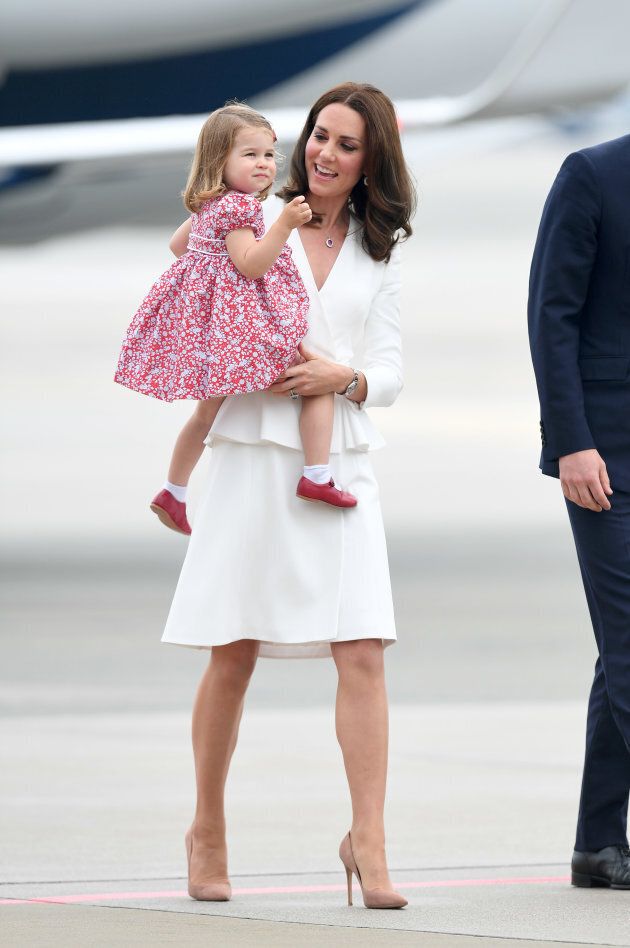 Princess Charlotte giving a wave while sitting in her mother's arms. (Photo by Karwai Tang/WireImage)