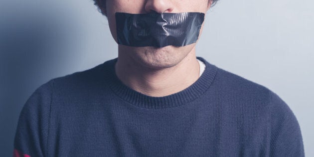 A young man has a big piece of black industrial tape covering his mouth