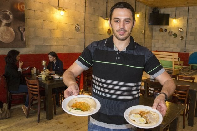 Kobi Tzafrir, the owner of Hummus Bar in the central Israeli town of Kfar Vitkin, displays plates of Hummus on Oct. 21, 2015 which he offers 50 per cent off to his customers for any table where Jews and Arabs sit together.