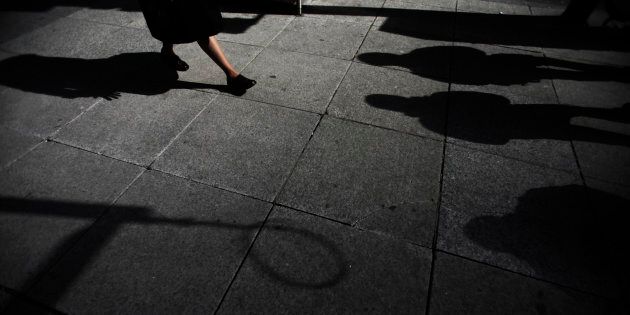 Shadows are seen as a woman walks down Bay Street in the financial district in Toronto, March 11, 2009.