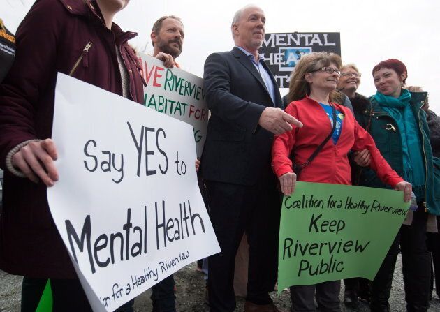 NDP Leader John Horgan stands with mental-health advocates after an election campaign announcement about mental health and addiction services at the Riverview Lands, the former site of a mental health facility, in Coquitlam, B.C., on April 17, 2017.