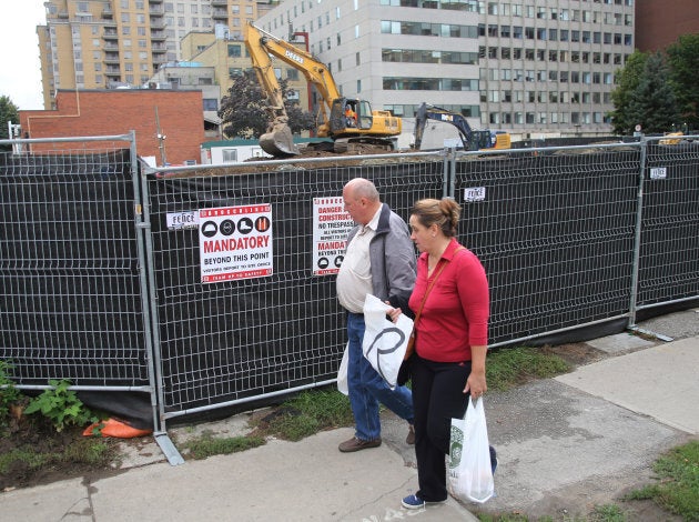 A couple pass a condominium construction site on what used to be a neighbourhood of single family homes in Toronto, Ont., October 3, 2016.