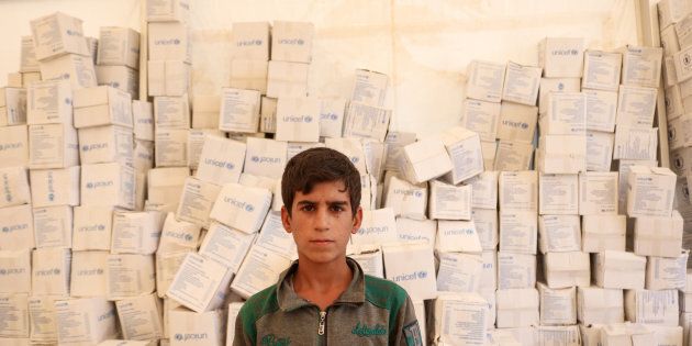 Rayan stands in the tent for new arrivals at Salamiyah camp. The UNICEF boxes behind him are UNICEF's hygiene kits that form part of the Multi-Sectoral Emergency Package (MSEP) to which WFP and UNFPA also contribute.
