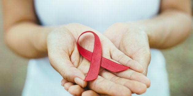 red aids ribbon in hand. soft focus on ribbon