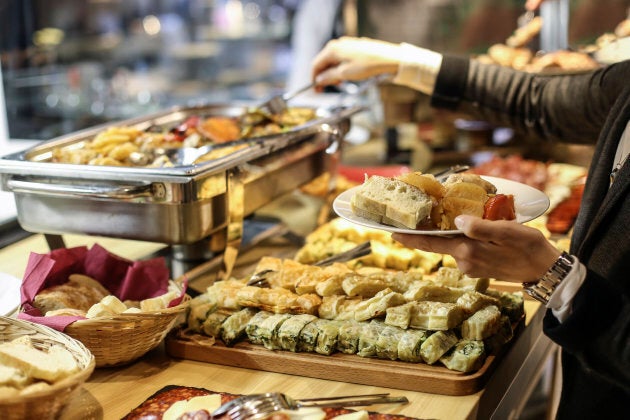 Unrecognizable Caucasian female choosing canape from a sideboard at a banquet.