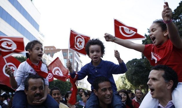 Protesters wave flags and shout slogans during a demonstration in Tunis March 20, 2012. Thousands of secular Tunisians marched in the capital on Tuesday, the country's independence day, to show their rejection of growing calls by conservative Salafi Islamists to transform post-revolutionary Tunisia into an Islamic state.