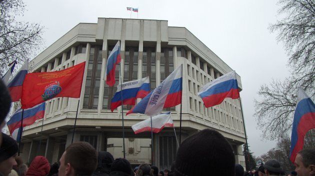 Pro-Russian protesters hold Russian flags as they rally in front of the Crimean parliament in Simferopol on February 27, 2014.