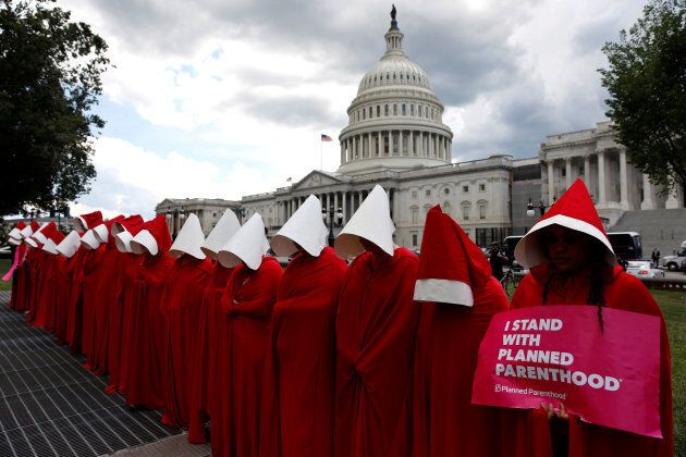 Women dressed as handmaids from the novel, film and television series "The Handmaid's Tale" demonstrate against cuts for Planned Parenthood in the Republican Senate healthcare bill at the U.S. Capitol, June 27, 2017.