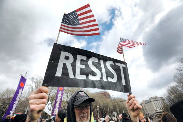 A protester holds a "resist" sign as Indigenous activists and supporters hold a protest march and rally in opposition to the Dakota Access and Keystone XL pipelines in Washington, D.C., March 10, 2017.