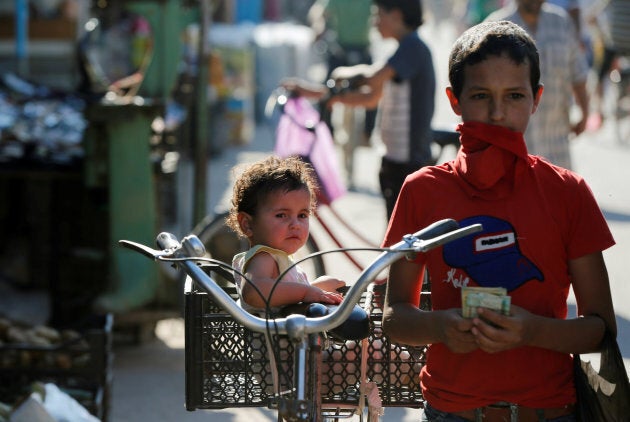 A Syrian child sits in a basket on a bicycle at the main market during the Muslim fasting month of Ramadan at the Al-Zaatari refugee camp in Mafraq, Jordan, near the border with Syria June 1, 2017.