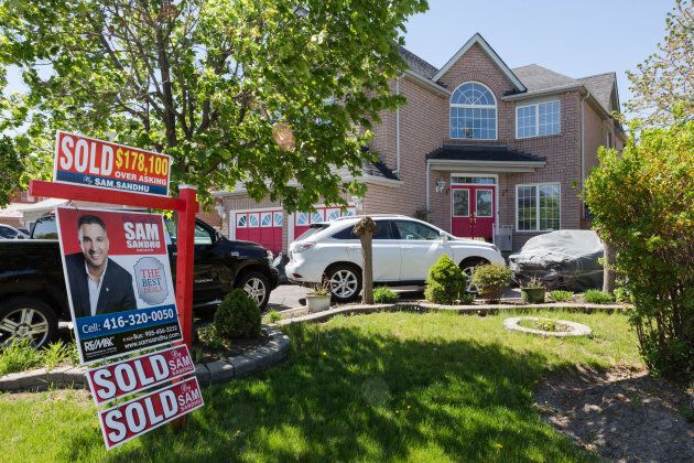 A 'Sold $178,100 Over Asking' sign is displayed outside of a house in Brampton, Ont., on Saturday, May 20, 2017.