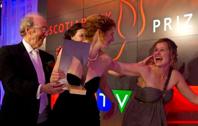 Founder Jack Rabinovitch holds the trophy as Johanna Skibsrud, receives a hug from her sister Kristin Skibsrud Ross (right) in November of 2010. (PHOTO: David Cooper/Toronto Star via Getty Images)