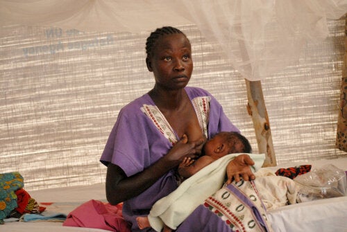 Onesta, from South Sudan, breastfeeds her two-month-old daughter Diana in a sweltering refugee tent.