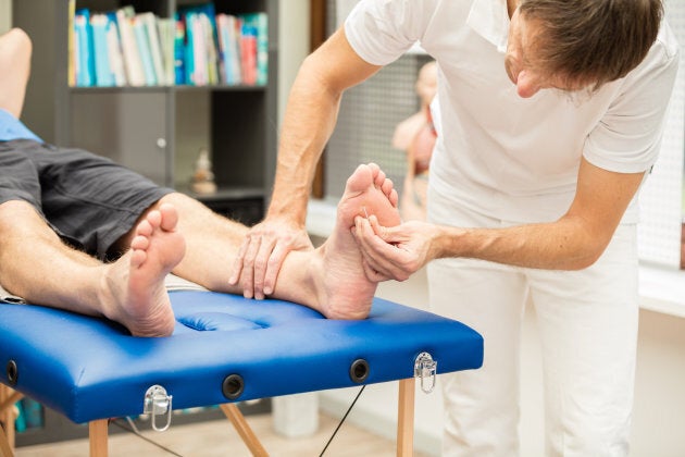 A doctor, testing the sensibility of a patient's foot. This test is often used for checking neuropathy of diabetic patients. XXXL size image.