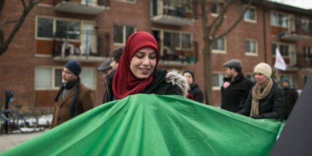 People carry a massive flag during a march against racism and Islamophobia in Montreal, Que., on March 26, 2017.