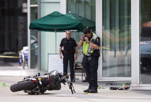A police officer photographs a motorcycle after a stunt driver working on the movie "Deadpool 2" died after a crash on set, in Vancouver on Aug. 14, 2017.