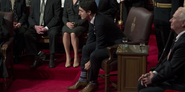 Canada's Prime Minister Justin Trudeau pulls up his socks before the start of the Speech from the Throne in the Senate chamber on Parliament Hill in Ottawa, Canada December 4, 2015. (REUTERS/Fred Chartrand/Pool)