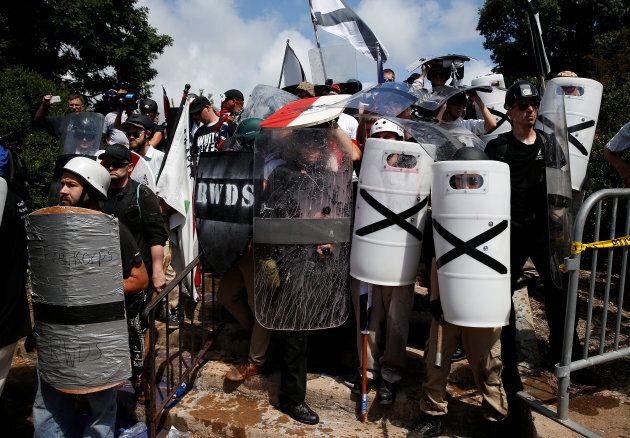 White supremacists shelter behind their shields after clashing with counter protesters at a rally in Charlottesville, Virginia, U.S., Aug. 12, 2017.