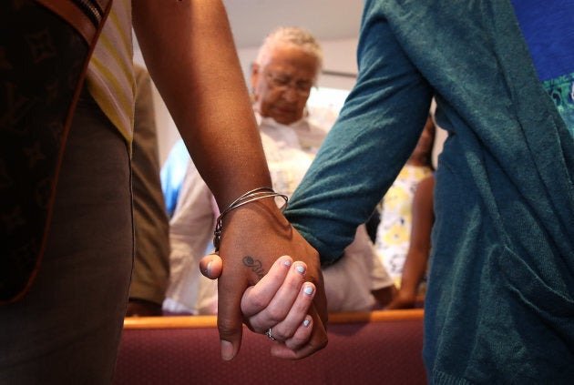 Worshipers hold hands during morning services at Mount Zion First African Baptist Church Aug. 13, 2017 in Charlottesville, Virginia. The city of Charlottesville is still reeling following violence at a 'Unite the Right' rally held by white nationalists, neo-Nazis and members of the alt-right.