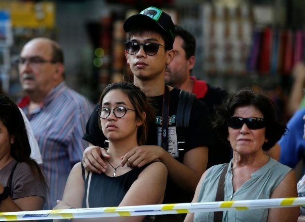 People stands behind police tape on a street in Barcelona on Thursday.