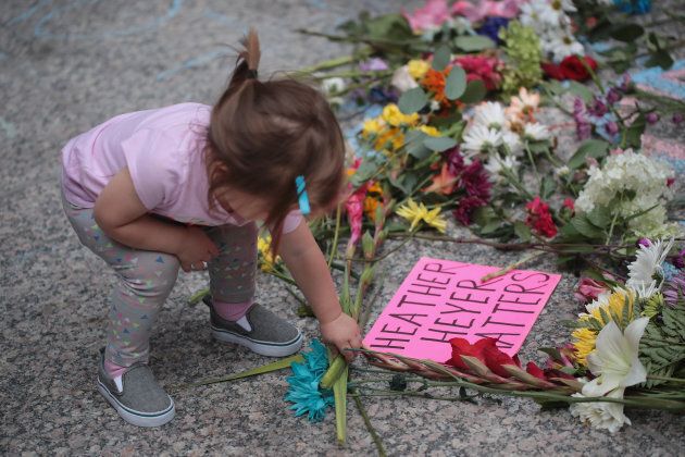 A young girl puts flowers on a memorial to Heather Heyer that was chalked on the pavement during a demonstration on August 13, 2017 in Chicago, Illinois. Heyer was killed and 19 others were injured in Charlottesville, Va. when a car plowed into a group of activists who were preparing to march in opposition to a nearby white nationalist rally.