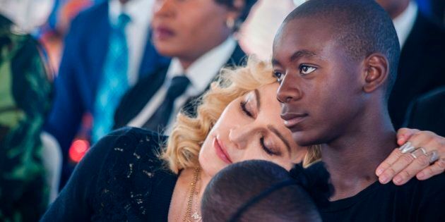 Madonna rests her head on the shoulder of her son David Banda during the opening ceremony of the Mercy James Children's Hospital at Queen Elizabeth Central Hospital in Blantyre, Malawi, on July 11, 2017. (AMOS GUMULIRA/AFP/Getty Images)