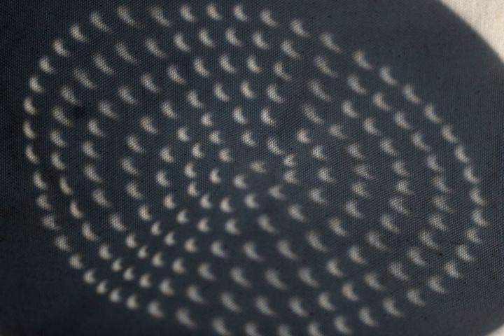A steaming pot shows the partial solar eclipse in its shadows in Toronto on Aug. 21, 2017.