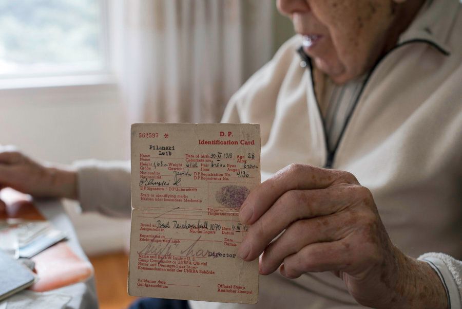 Lejb Pilanski holds his displaced person identification card from 1947 Germany.