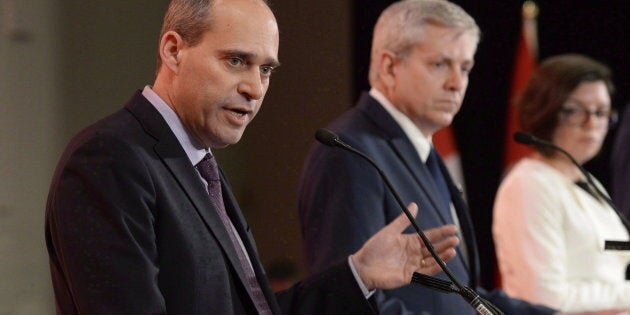 Guy Caron speaks as Charlie Angus and Niki Ashton look on in the first debate of the federal NDP leadership race in Ottawa on March 12, 2017.