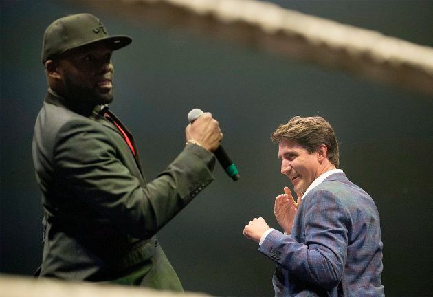 Prime Minister Justin Trudeau, right, jokes around with ring announcer Ainslie Bien-Aime during a charity boxing event in Montreal on Aug. 23, 2017.