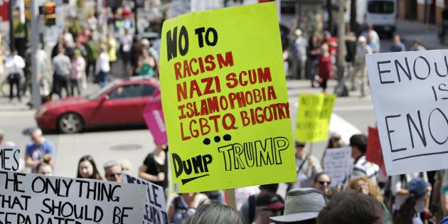 Demonstrators hold signs during an anti-racism rally in front of the U.S. Embassy in Ottawa, Ontario, Canada on Aug. 23, 2017. The peaceful gathering was organized in response to white nationalist and other right-wing group demonstrations in Charlottesville, Virginia, that resulted in the death of a young woman on August 12. Photographer: David Kawai/Bloomberg via Getty Images
