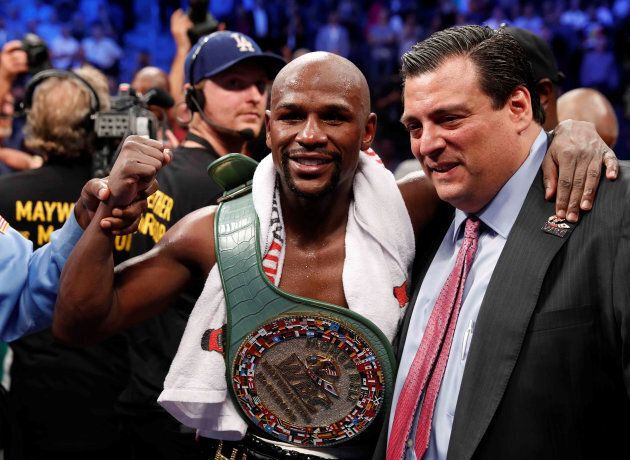 Floyd Mayweather Jr. celebrates with the belt and President of the WBC Mauricio Sulaiman after winning the fight.