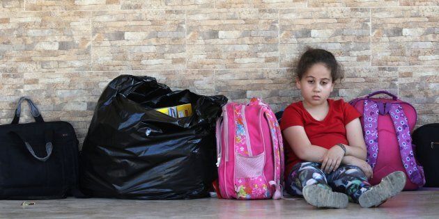 A Palestinian refugee who fled the Ain al-Hilweh camp, Lebanon's largest Palestinian refugee camp, due to ongoing clashes between Palestinian security forces and Islamist fighters for the third consecutive day, is seen sitting next to her belongings at a mosque in the southern coastal city of Sidon on Aug. 19, 2017.
