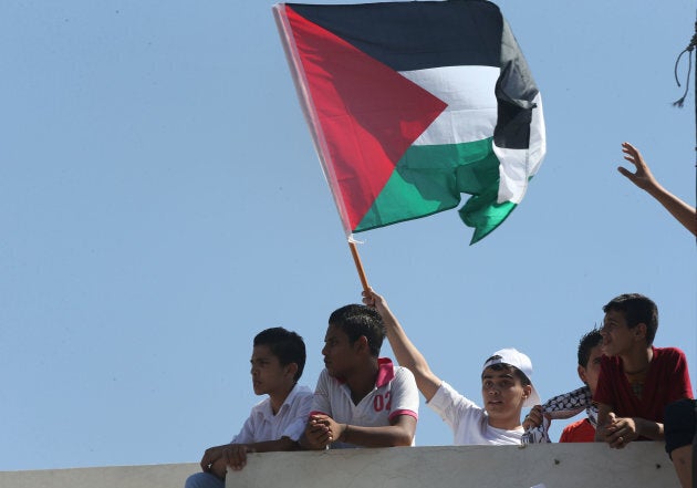 People participate in a protest to denounce plans of downsizing services to Palestinian refugees benefiting from the United Nations Relief and Works Agency (UNRWA) in front of the UNRWA schools compound at the Al-Wehdat camp for Palestinian refugees, Aug. 12, 2015 in Amman, Jordan.