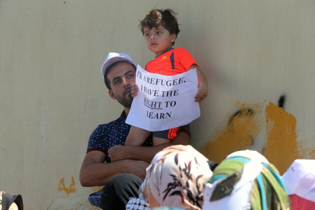 People participate in a protest to denounce plans of downsizing services to Palestinian refugees benefiting from the United Nations Relief and Works Agency (UNRWA) in front of the UNRWA schools compound at the Al-Wehdat camp, Aug. 12, 2015 in Amman, Jordan.