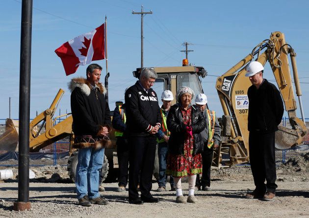 Former Canadian Prime Minister Stephen Harper, second from left, listens as elder Eva Otokiak, second from right, delivers a prayer during a ground breaking for the Canadian High Arctic Research Station in Cambridge Bay, Nunavut, on August 23, 2014.