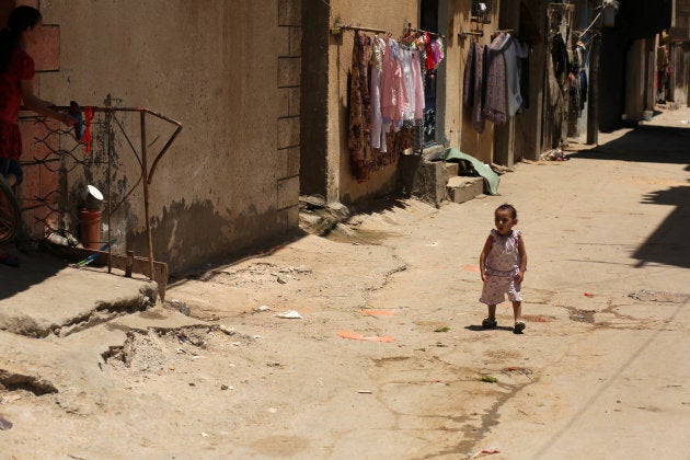 A Palestinian refugee girl walks outside her family house in the streets at al-Shati refugee camp in Gaza City on July 4, 2017.