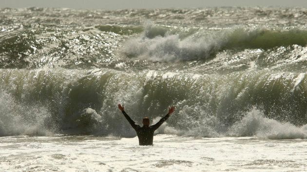 A man wades into the waves of a storm surge created by the passing of Hurricane Irene at Lawrencetown beach, N.S. on Aug. 29, 2011.