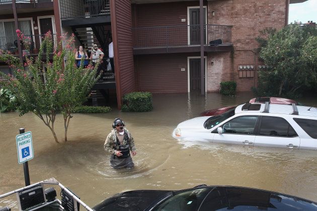 Scott Robertson helps rescue people from an apartment complex after it was inundated with water following Hurricane Harvey on Aug. 30, 2017.