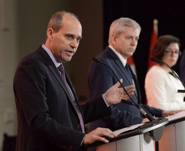 Guy Caron speaks as Charlie Angus and Niki Ashton look on in the first debate of the federal NDP leadership race in Ottawa on March 12, 2017.