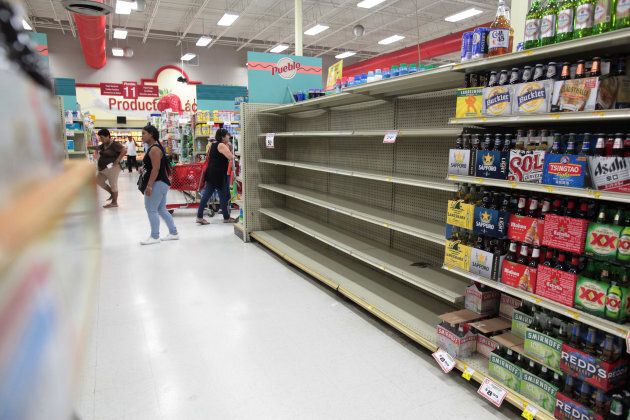 Customers walk near empty shelves that are normally filled with bottles of water after Puerto Rico Governor Ricardo Rossello declared a state of emergency in preparation for Hurricane Irma.