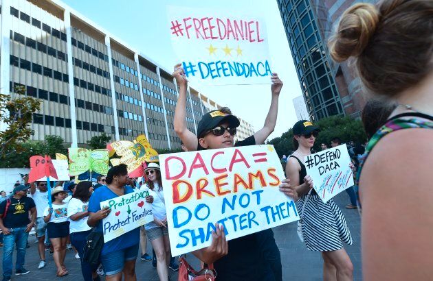 Young immigrants and supporters walk holding signs during a rally in support of Deferred Action for Childhood Arrivals (DACA) in Los Angeles.