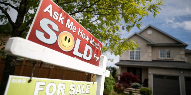 A real estate sign stands in front of a house in Vaughan, a suburb in Toronto, Canada, May 24, 2017.