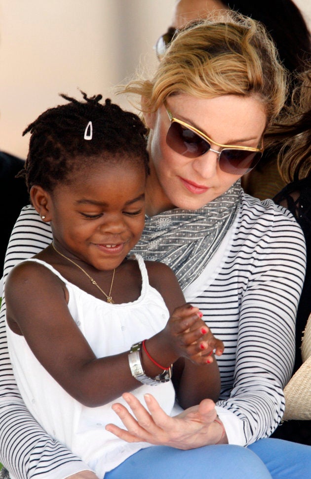 Madonna sits with her adopted daughter Mercy James in Lilongwe, April 6, 2010. REUTERS/Mike Hutchings