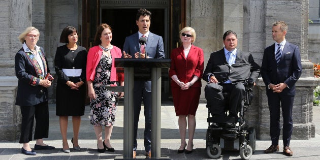 Prime Minister Justin Trudeau speaks to the press outside Rideau Hall after announcing changes to his cabinet in Ottawa, Ontario on August 28, 2017. From left, Minister of Crown-Indigenous Relations and Northern Affairs Carolyn Bennett, Minister of Health Ginette Petitpas Taylor, Minister of Indigenous Services Jane Philpott, Trudeau, Minister of Public Works Carla Qualtrough, Minister of Sport and Persons with Disabilities Kent Hehr and Minister of Veterans Affairs and Associate Minister of National Defence Seamus O’Reagan. (LARS HAGBERG/AFP/Getty Images)