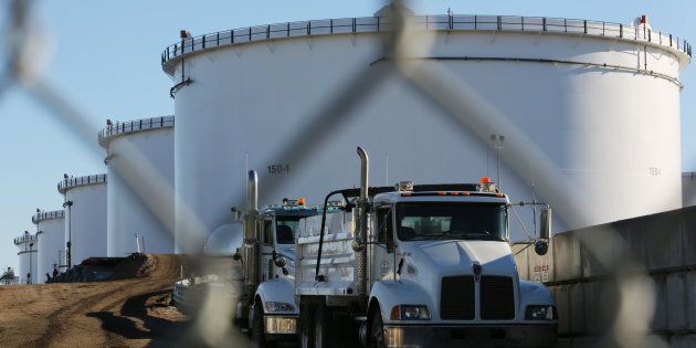 Dump trucks are parked near crude oil tanks at Kinder Morgan's North 40 terminal expansion construction project in Sherwood Park, near Edmonton on Nov. 13, 2016.