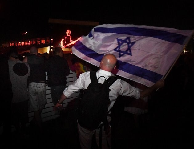 Pro-Israel supporter Paul Antey waves the Israeli flag in protest against what he says is the anti-semite political beliefs of artist Roger Waters as he performs on stage during the third day of the Desert Trip music festival at Indio, Calif. on Oct. 9, 2016.