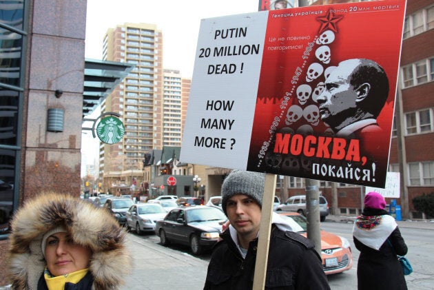 People hold placards and Ukrainian flags during a peace march from Toronto's City Hall to the Russian Consulate, in support of Ukraine on March 8, 2014, in Toronto, Ont.